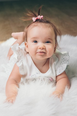 little girl with a tail on her head crawling on the floorの写真素材