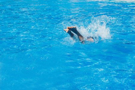 a man jumps into the pool. Swimmer in the waterの写真素材