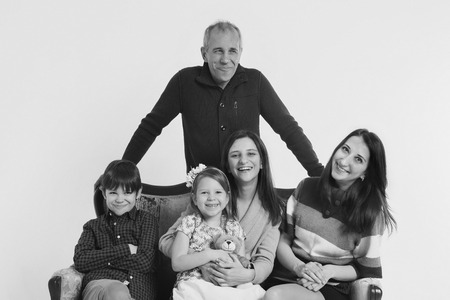 group of people on a white background: adults and children with toys sitting on the same couchの写真素材