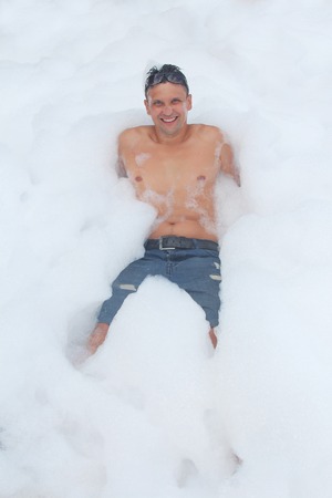 the man in glasses has fun in the white foamの写真素材