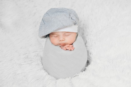 newborn baby lies in a beautiful hatの写真素材