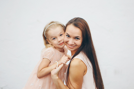 baby in the arms of the mother. on white background Woman holding a child. Fashion for girl.の写真素材