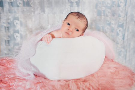 newborn baby wrapped in a blanket sleeping in a basketの写真素材