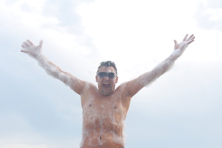 the man in glasses has fun in the white foamの写真素材