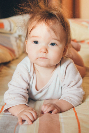 little girl with a tail on her head crawling on the floorの写真素材