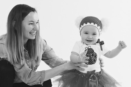 baby in the arms of the mother. on white background Woman holding a child. Fashion for girl.の写真素材
