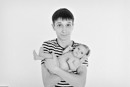 Dad holds the baby in his arms. The concept of educating the father of young children, Happy childhood, a friendly family.の写真素材