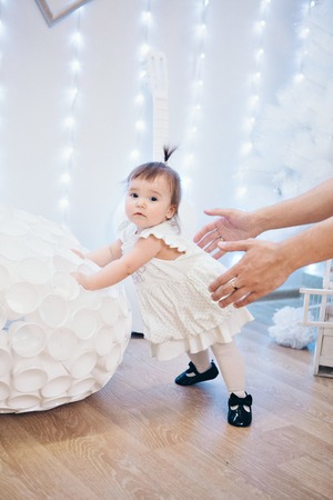Cute baby learning to walk and make his first steps. mom is holding his hand. child's feet close up, copy spaceの写真素材