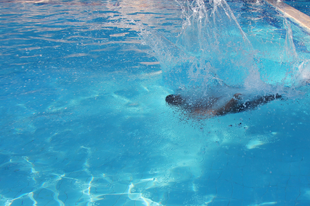 a man jumps into the pool. Swimmer in the waterの写真素材