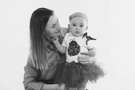 baby in the arms of the mother. on white background Woman holding a child. Fashion for girl.の写真素材