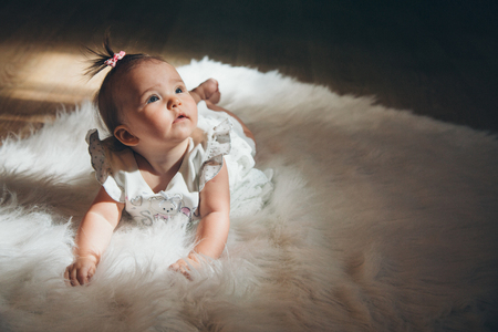 little girl with a tail on her head crawling on the floorの写真素材
