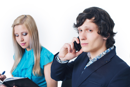 portrait of 2 businessmen on a white background. A man talking on the phone, a woman writes in a notebookの写真素材
