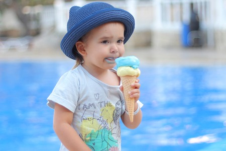 portrait of a child who eats ice cream. Grimy face in foodの写真素材
