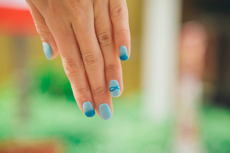 macro: blue manicure with a pattern of fish on the womans hand. Picture Christian symbol varnishの写真素材