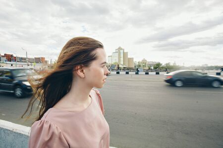 portrait of a beautiful girl on the background of the urban landscapeの写真素材