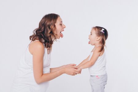 mother and daughter show each other language. Health and hygiene in women on a white backgroundの写真素材