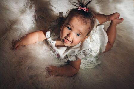 little girl with a tail on her head crawling on the floor
