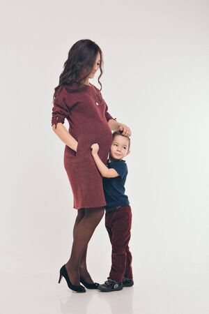 Happy kid girl hugging pregnant mother's belly, pregnancy and new life conceptの写真素材