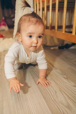 little girl with a tail on her head crawling on the floorの写真素材