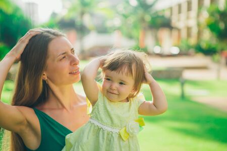 the child in the arms of his mother. A woman with a child in her arms against natureの写真素材