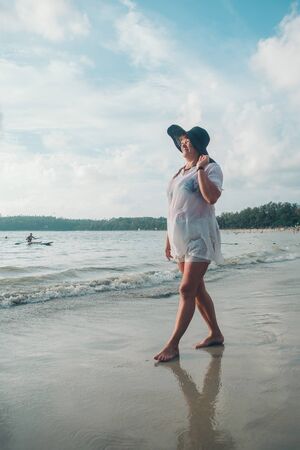 woman walking on the beach by the water. Full tourist on vacationの写真素材