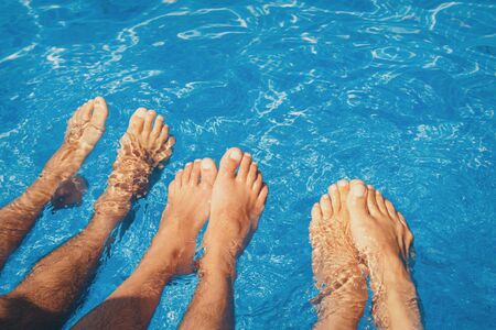 Stay at the resort. Men's legs on a large water background . Man swimming in the pool. he concept of recreation, relaxation, tourism.の写真素材