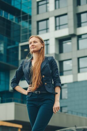 portrait of a beautiful girl with red haired on the background of the urban landscapeの写真素材
