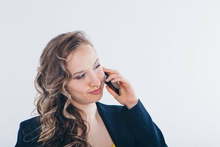the concept of employment, interviews, advertising digital technology - businesswoman talking on the phone. Smiling woman makes a call. Isolated on white background. Copy spaceの写真素材