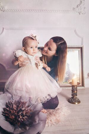 the child in the arms of his mother. A woman with a child in her arms next to a large flowerの写真素材