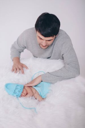 the concept of parenthood, children's Day, medicine, IVF-father looks at the sleeping newborn and stroking it. Isolated on white background.の写真素材