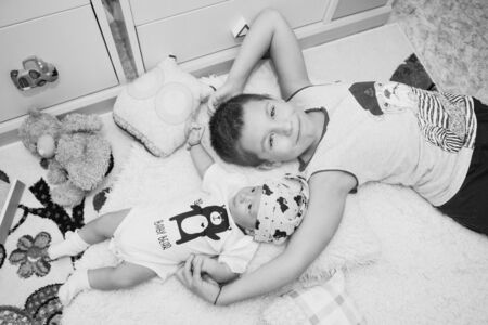 the concept of a healthy lifestyle, the protection of children, shopping - a teenager with a newborn baby playing together. Happy kids: brother and sister on white backgroundの写真素材