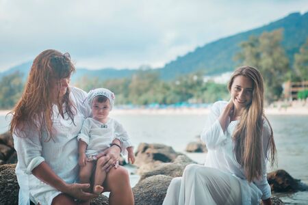 family holiday by the sea: man, woman and child on the beach. concept of travelの写真素材