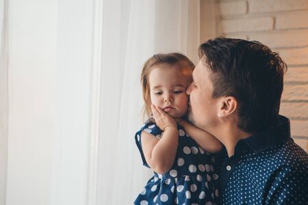 Dad holds the baby in his arms. The concept of educating the father of young children, Happy childhood, a friendly family.の写真素材