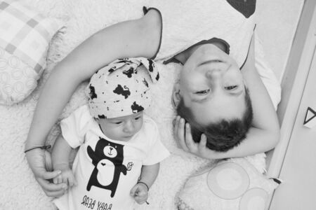 the concept of a healthy lifestyle, the protection of children, shopping - a teenager with a newborn baby playing together. Happy kids: brother and sister on white backgroundの写真素材
