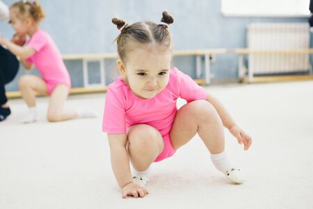 little girl engaged in recreational gymnastics. sports exercises and stretching: athleticsの写真素材