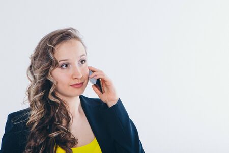 the concept of employment, interviews, advertising digital technology - businesswoman talking on the phone. Smiling woman makes a call. Isolated on white background. Copy spaceの写真素材