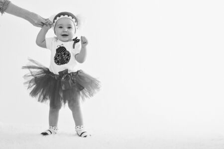 Cute baby learning to walk and make his first steps. mom is holding his hand. child's feet close up, copy spaceの写真素材
