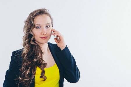 the concept of employment, interviews, advertising digital technology - businesswoman talking on the phone. Smiling woman makes a call. Isolated on white background. Copy spaceの写真素材