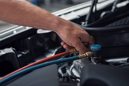 Car repair and cleaning concept - car engine close-up, wiping parts under the hoodの写真素材