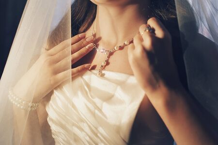 the bride tries on jewelry. The model shows the pendant. French manicure with rhinestonesの写真素材