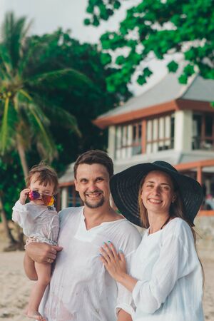 family holiday by the sea: man, woman and child on the beach. concept of travelの写真素材
