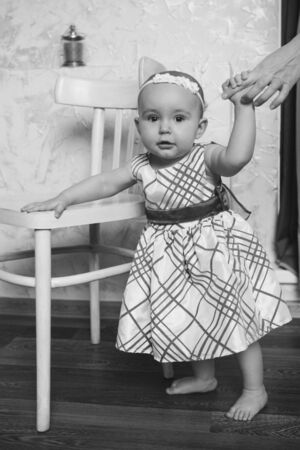 Cute baby learning to walk and make his first steps. mom is holding his hand. child's feet close up, copy spaceの写真素材