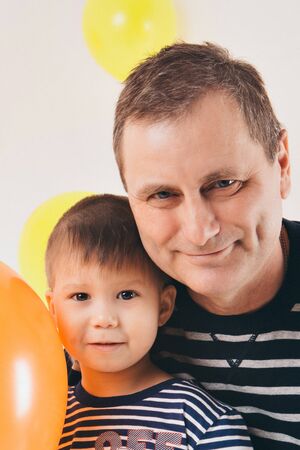 the concept of celebration, fun time spending - family at the party. adults and children on a white background among the colored balls celebrate their Birthdayの写真素材