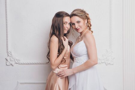 advertising of fashion for woman: dress, shoes. two happy girls smiling. Portrait of women hugging. The concept of relationships in the family, friends, sisters, couple in love. isolated on white background.の写真素材