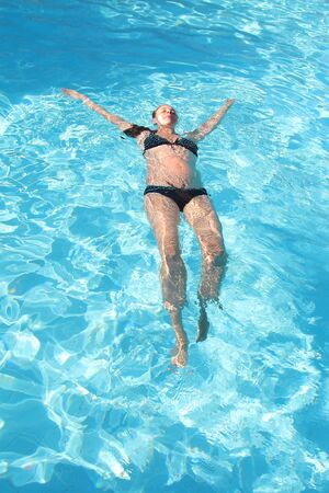 pregnant woman on vacation in the pool. The concept of Spa, swimming lessons, vacations, water treatment, IVFの写真素材