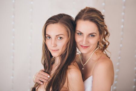 two happy girls smiling. Portrait of women hugging. The concept of relationships in the family, friends, sisters, couple in loveの写真素材