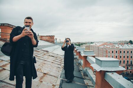 two photographers shoot on the phone on the roof. Photo and video advertising. tourismの写真素材