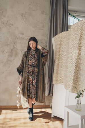 beautiful caucasian woman in Japanese kimono and black shoes on the background of the home interior. Model advertising clothesの写真素材