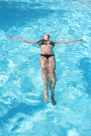 pregnant woman on vacation in the pool. The concept of Spa, swimming lessons, vacations, water treatment, IVFの写真素材