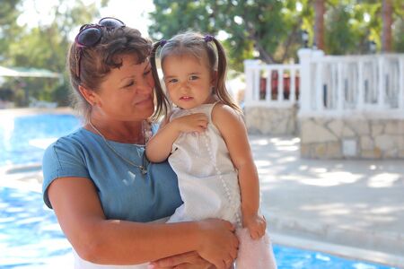 the concept of a healthy lifestyle, the protection of children, shopping - baby in the arms of the mother. Woman holding a child on the sea background. Travelの写真素材